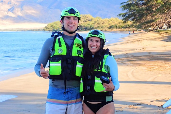a young boy standing next to a body of water
