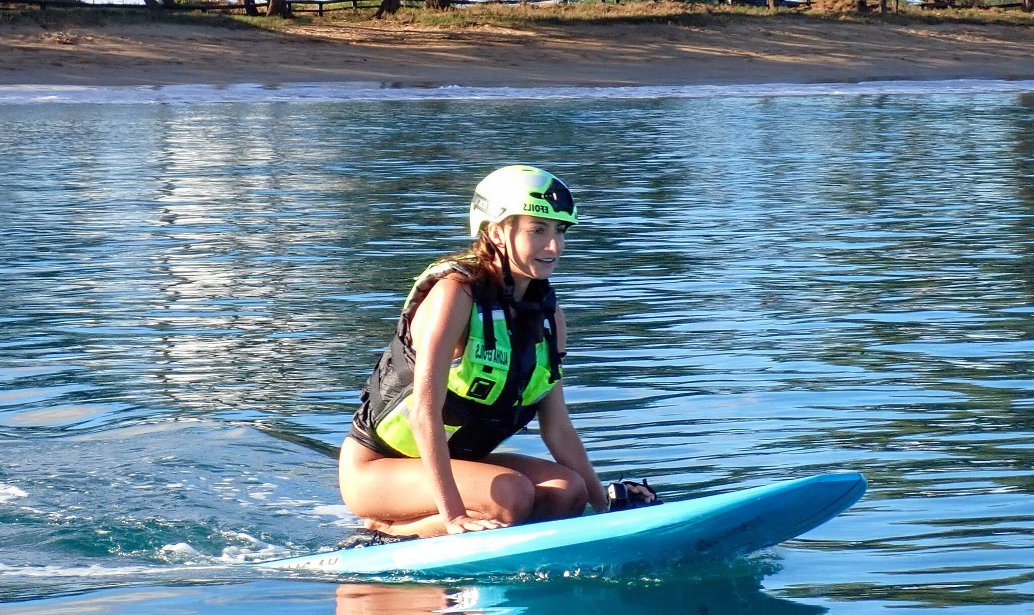 a woman riding on the back of a boat in the water