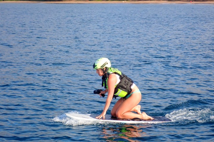 a person riding on the back of a boat in a body of water