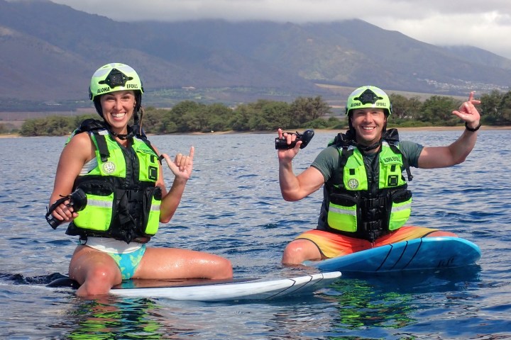 a group of people riding on the back of a boat in the water