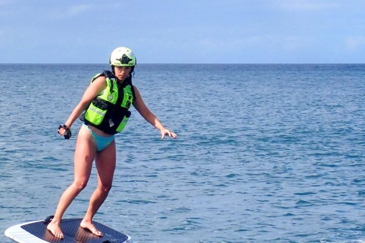 a girl riding a wave on a surf board on a body of water