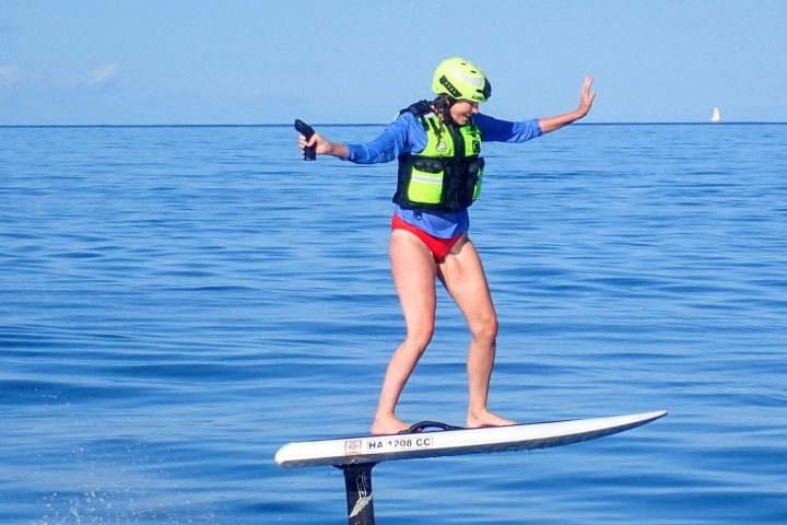 a woman riding a board on a body of water