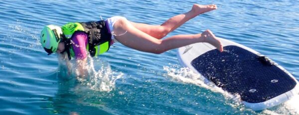 a young girl riding a wave on a surfboard in the water