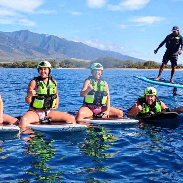 a group of people riding on the back of a boat in the water