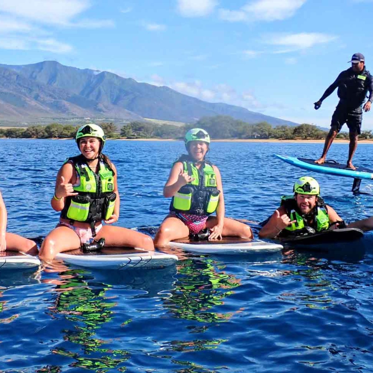 a group of people riding on the back of a boat in the water