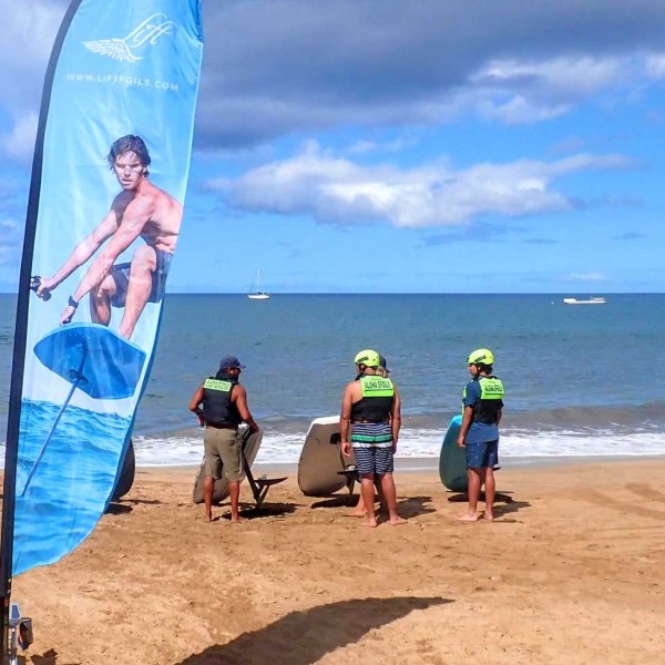 a person standing in front of a beach holding a surf board